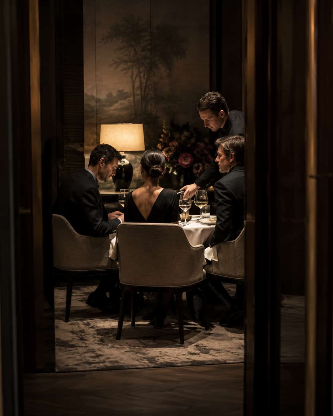 Intime Dinner-Szene in einem privaten Speiseraum mit wenigen stilvoll gekleideten Gästen, exzellentem Service und spürbarer Privatsphäre.
