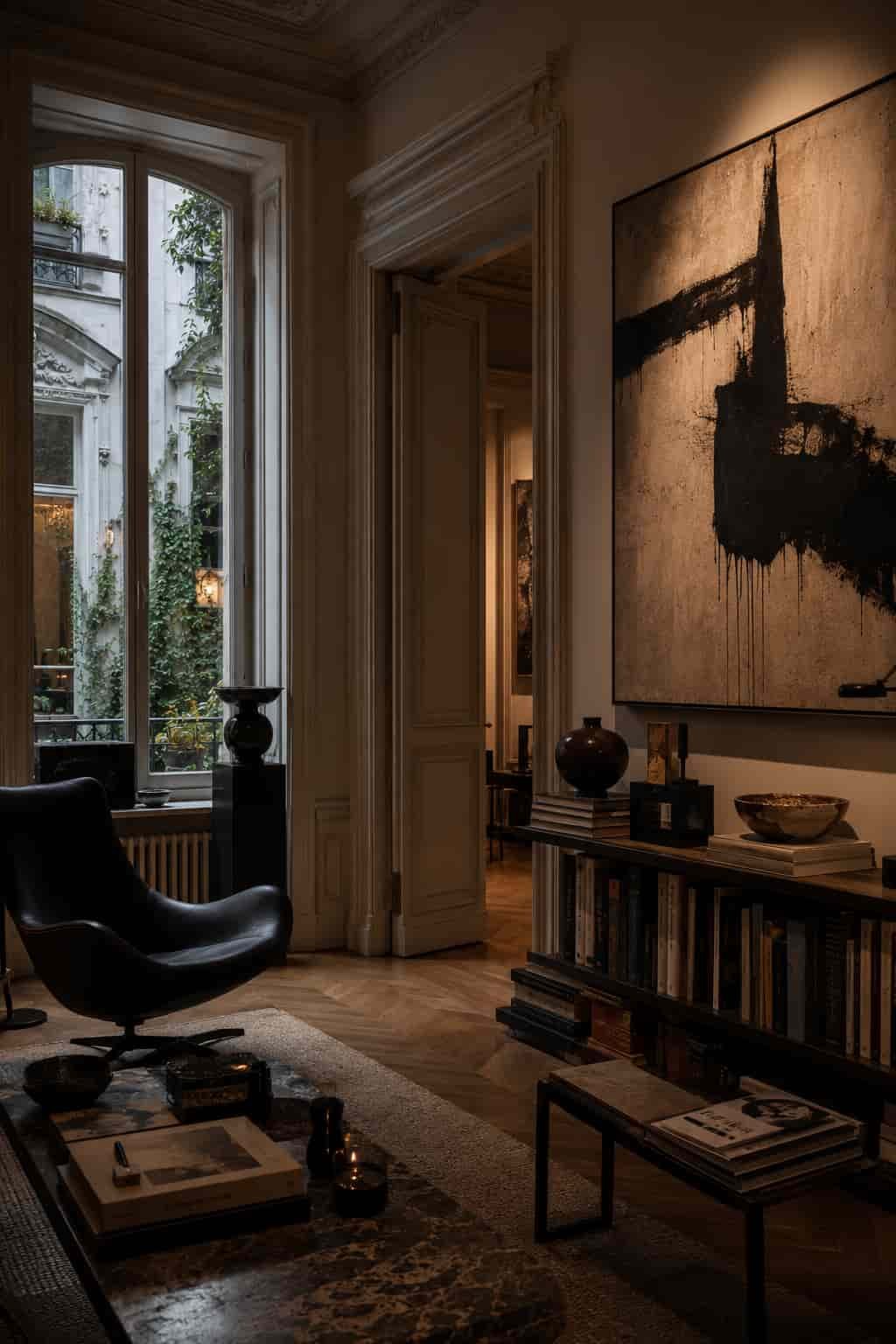 Privater Galeriesalon mit Kunstwerk, Designstuhl, Altbaudetail, Büchern und ruhigem Licht als Ausdruck von kulturellem urbanem Luxus.