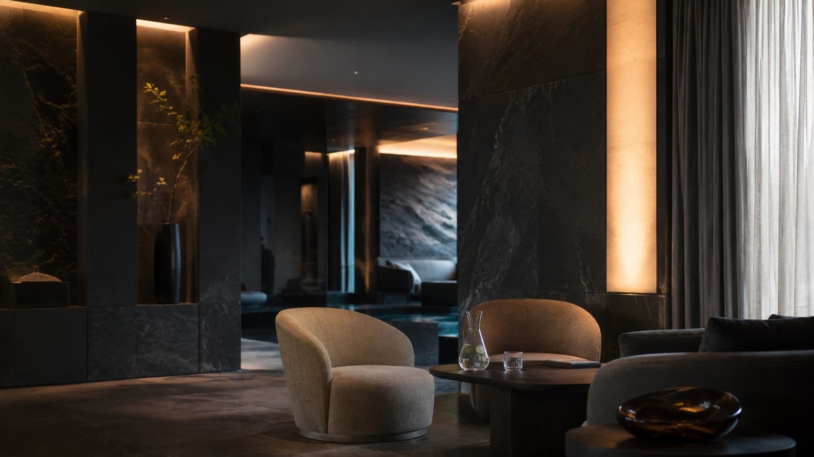 Private Wellness Club Lounge mit Naturstein, indirektem Licht, Wasser und ruhiger Diskretion.