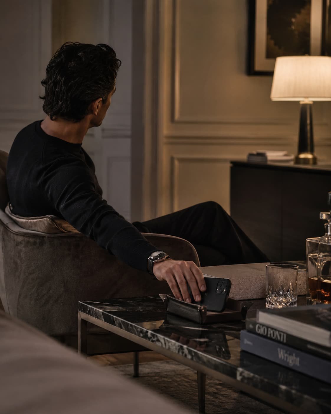 Ruhiger Abendmoment in elegantem Interior, in dem Smartphone und Wearable bewusst zur Seite gelegt werden.